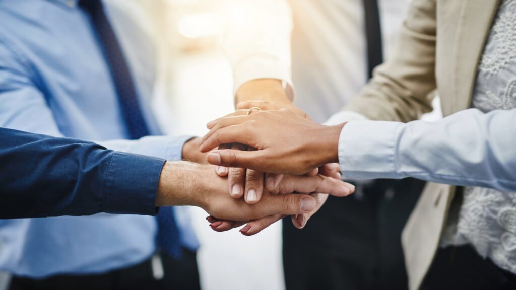 Equipo de profesionales de MACHU PICCHU VIVE VIP uniendo sus manos en señal de compromiso y trabajo en equipo para brindar el mejor servicio turístico en Cusco.